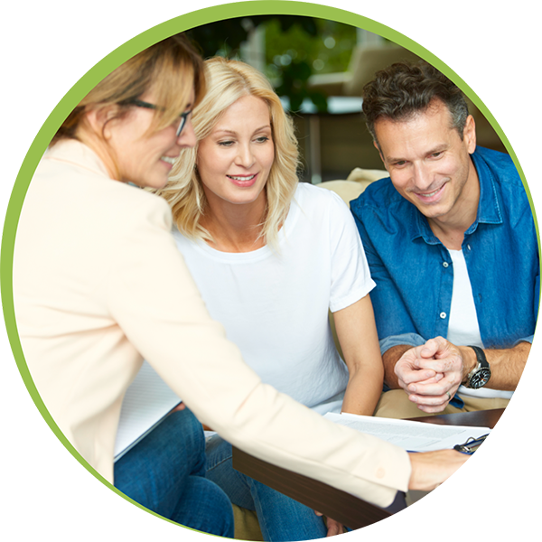 Younger couple reviewing papers with woman advisor