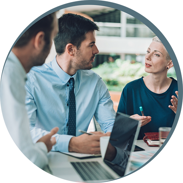 People speaking at table with laptop