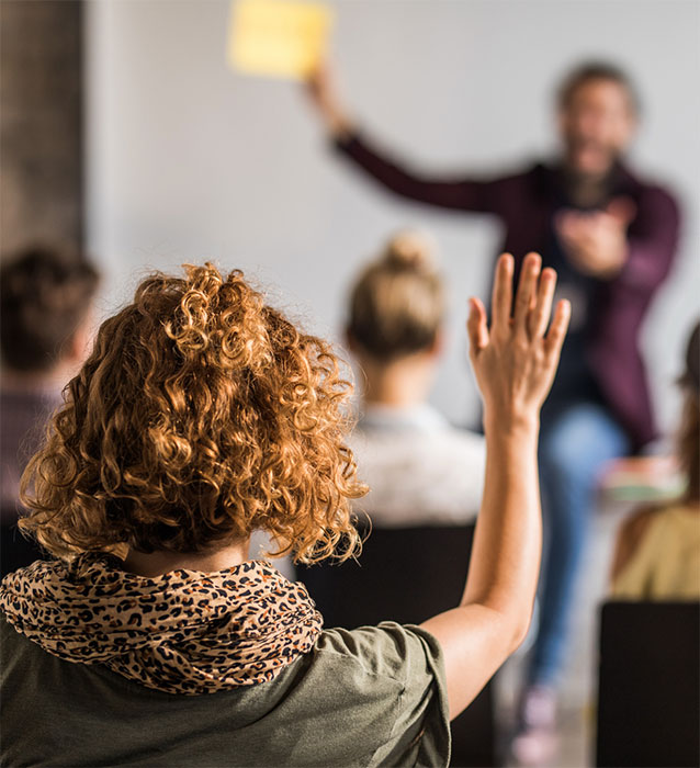 Womain raising hand during lecture