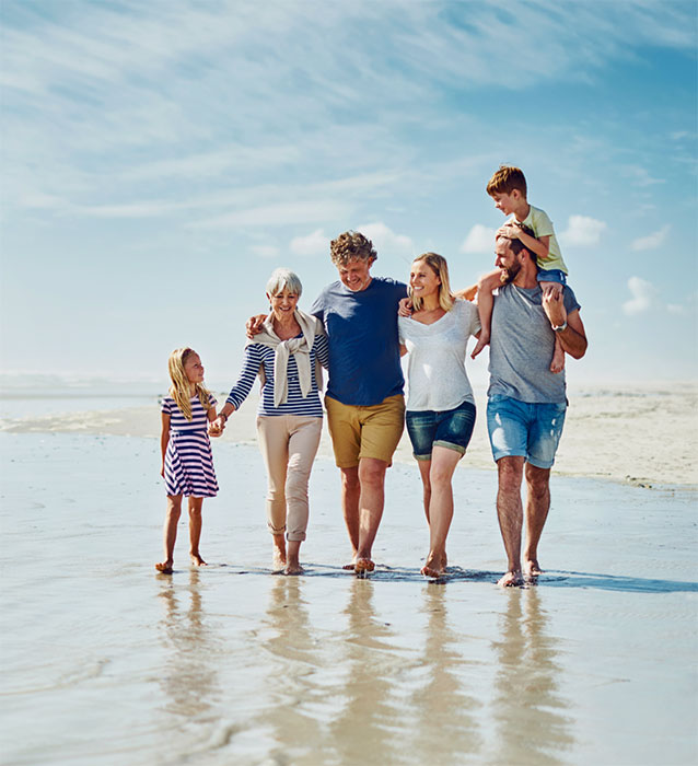 Family walking along beach shore